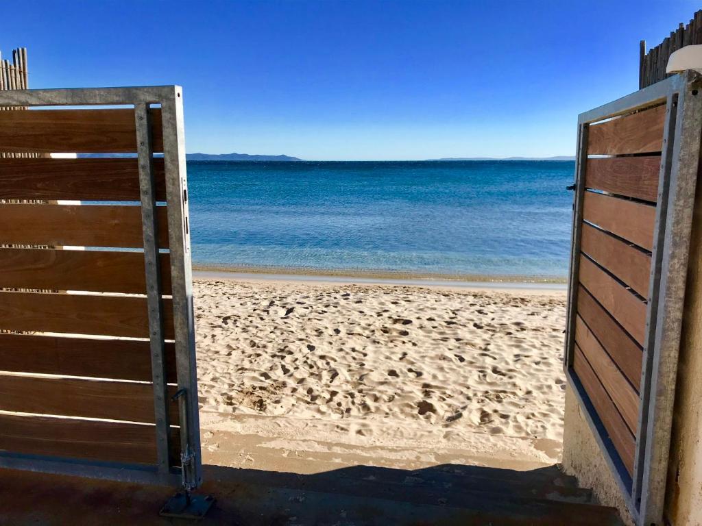 - une porte ouverte menant à une plage donnant sur l'océan dans l'établissement Le Club des Cigales, à Hyères