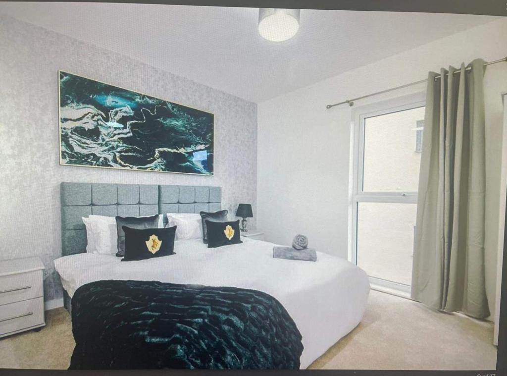 a bedroom with a large white bed and a window at Cosy City Apartment in Manchester in Manchester