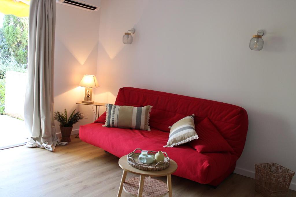 a red couch in a living room with a table at Résidence Fior di Rena in Saint-Florent