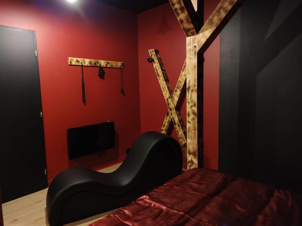 a bedroom with a black bed and a wooden x at La Love room in Arbois