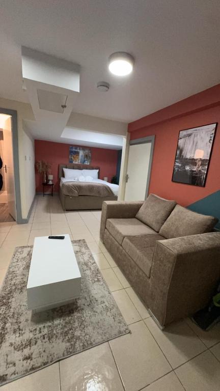 a living room with a couch and a bed at Large Studio for Contractors, Families, Relocation Near New Cross Hospital in Monmore Green