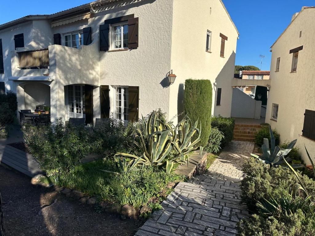 une maison blanche avec des plantes devant dans l'établissement Le Charme bleu d'Azur, à Saint-Raphaël