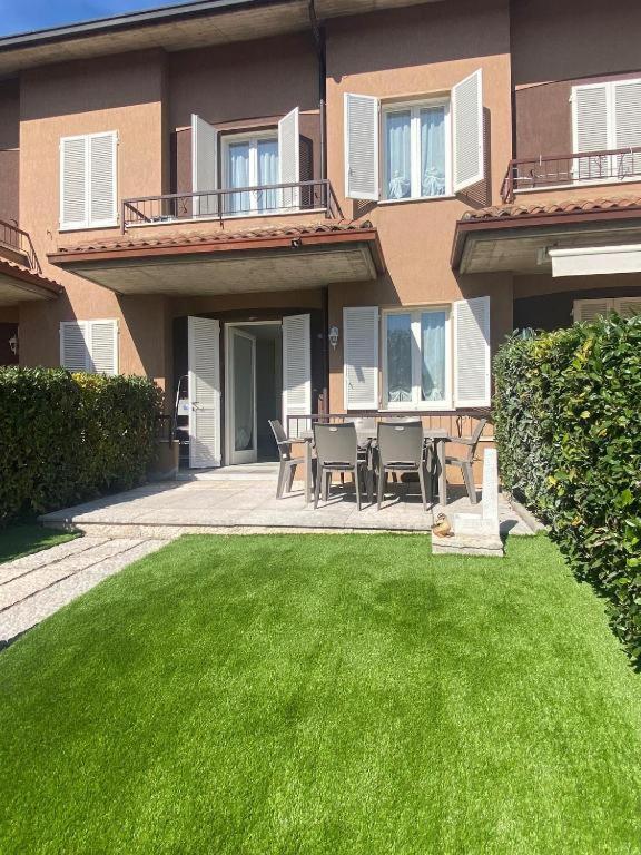 a house with a patio with a table and chairs at Sirmione - Independent House with Garden in Sirmione