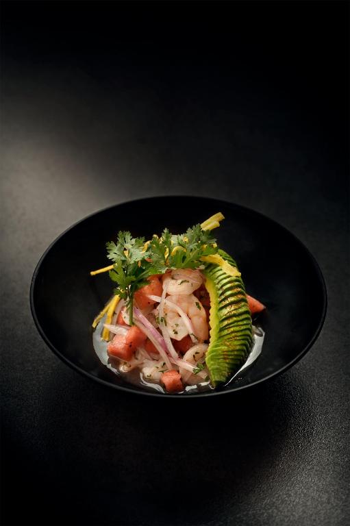 a black plate with a dish of food on a table at The Charlee Hotel in Medellín