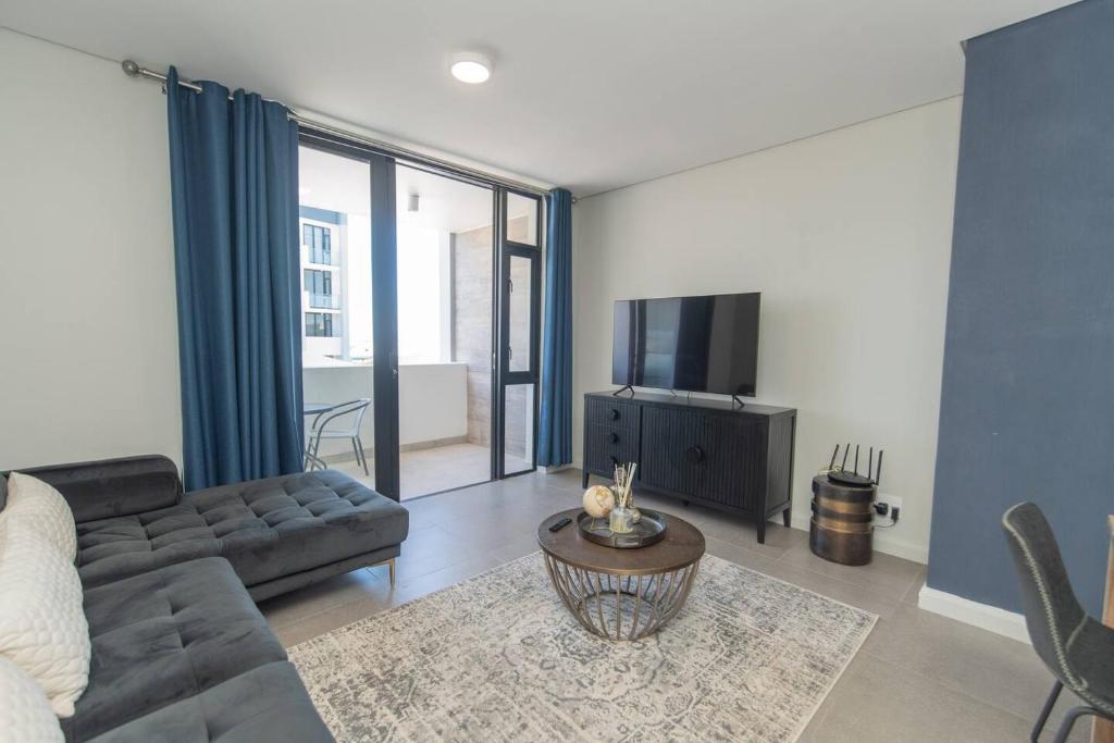 a living room with a couch and a tv at Infinite Tide Bellamare in Summerstrand