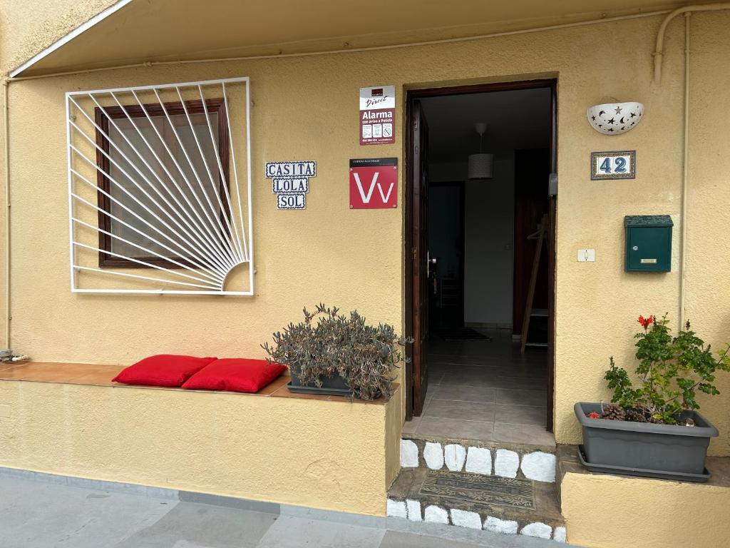 a building with two red pillows sitting on a porch at Casita Lola Sol in Puntillo del Sol
