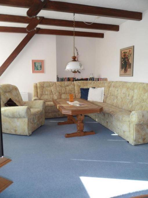 a living room with a couch and a table at Unterm-Reetdach-2 in Borkum