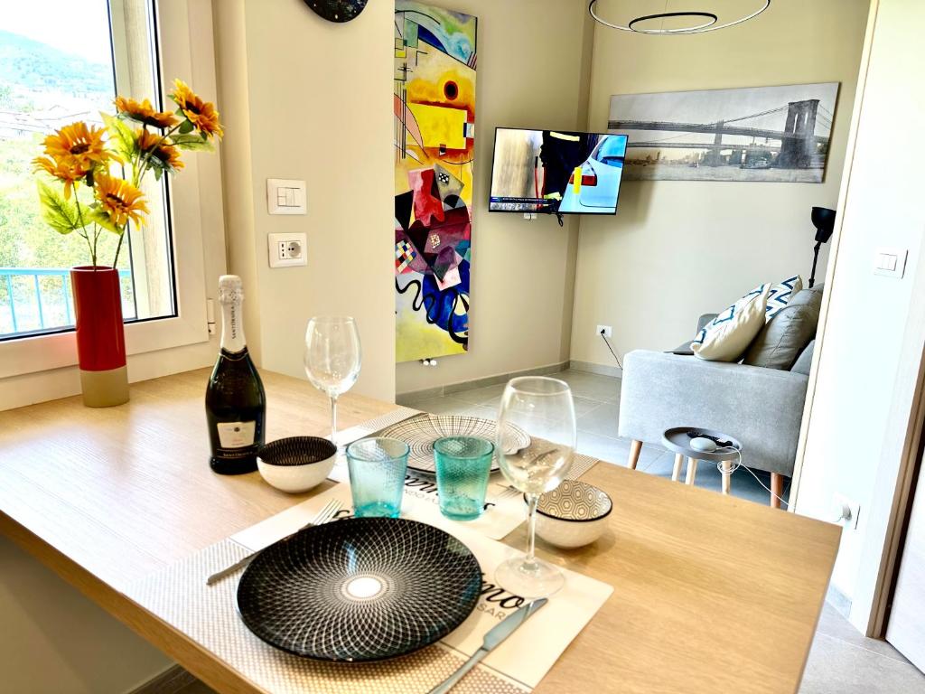 a table with wine glasses and a plate on it at Casa Diana in Sanremo