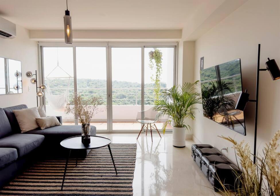 una sala de estar con un sofá y una mesa en Luxury Beachfront Apartment Near Panama City, en ArraijÃ¡n