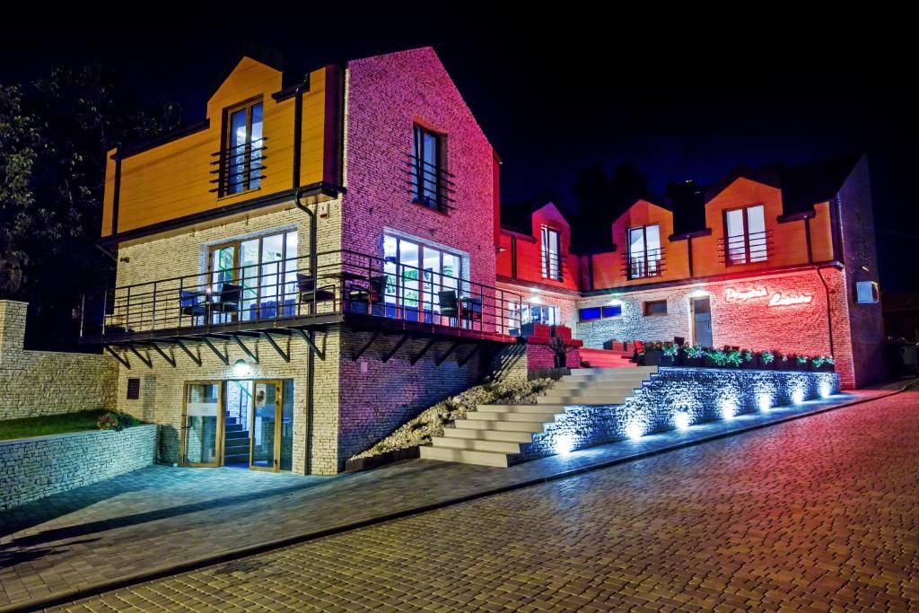 a building with lights on the side of it at night at Przystań Leśniów in Żarki