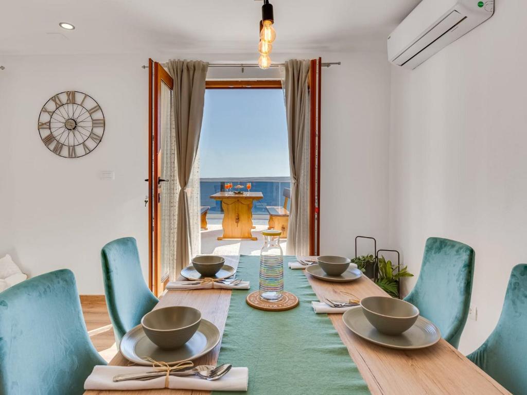 a dining room with a wooden table and blue chairs at Magic Sea View - Apartments Rina in Karlobag