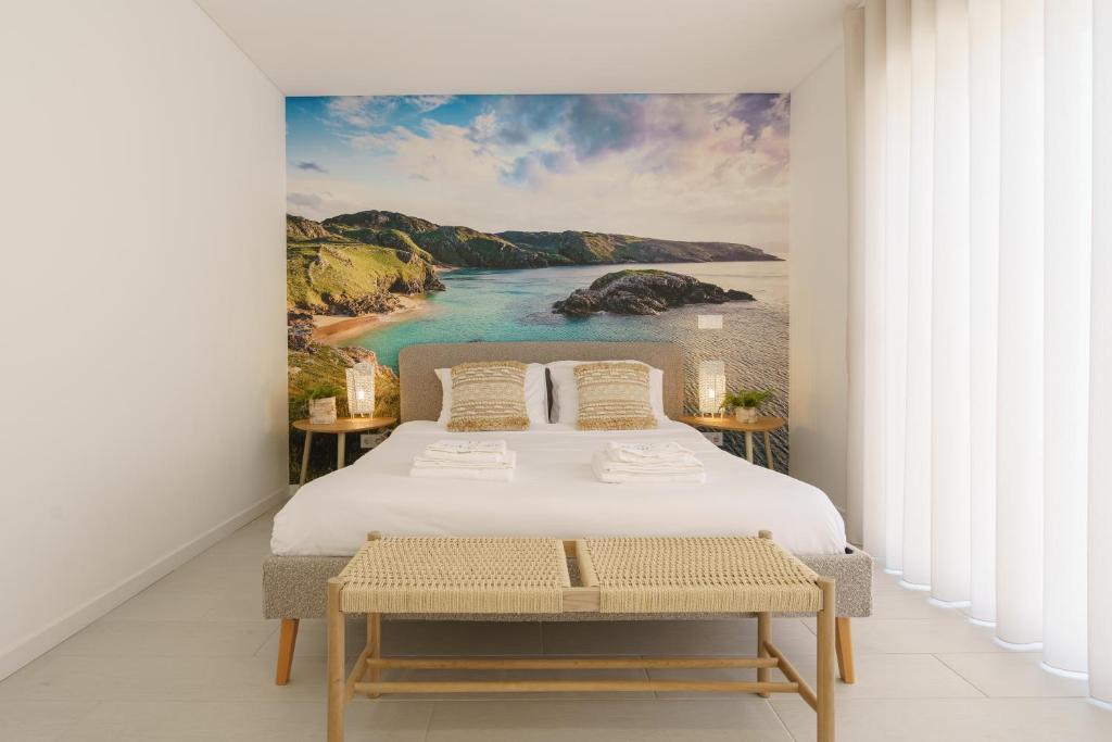 ein Schlafzimmer mit einem Bett und einem Gemälde eines Strandes in der Unterkunft Villa Lola in Mariquiteira