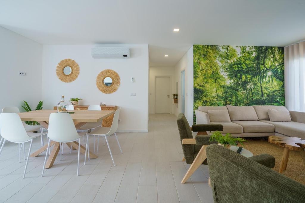 ein Wohnzimmer mit Tisch und Stühlen und einer Couch in der Unterkunft Villa Lola in Mariquiteira