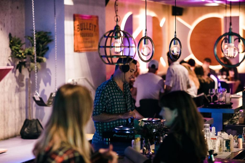 a man standing at a bar with headphones on at Generator Stockholm in Stockholm