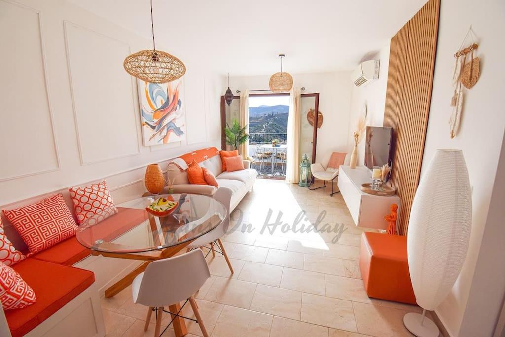 a living room with a couch and a glass table at Piso Amaranta, Frigiliana Modern 2 bedroom, 2 bathroom Apartment with Air conditioning and Pool HansOnHoliday Rentals in Frigiliana