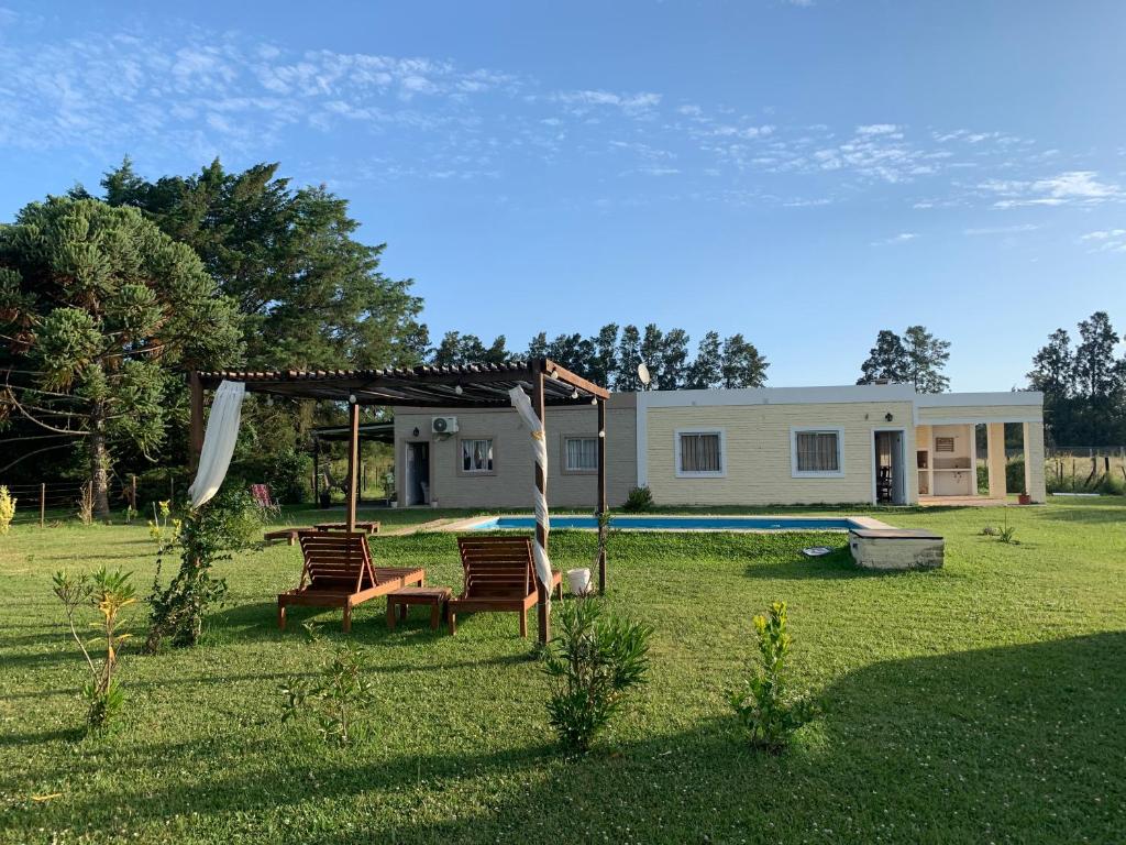 Un patio con dos sillas y una piscina. en Chacra DOS TEROS I y II, en Gualeguay