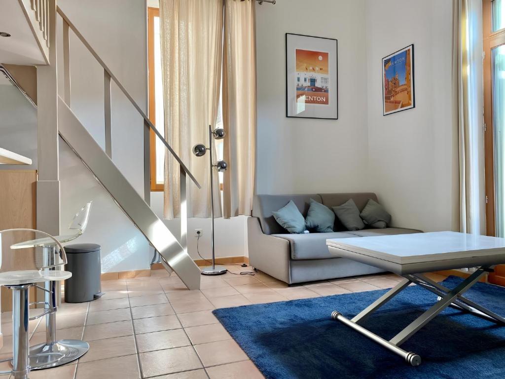un salon avec un canapé et un escalier dans l'établissement Appartement terrasse centre,, à Menton