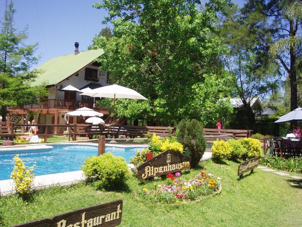 a swimming pool with a sign in the middle of a yard at Alpenhaus Bier und Gasthaus in Tigre