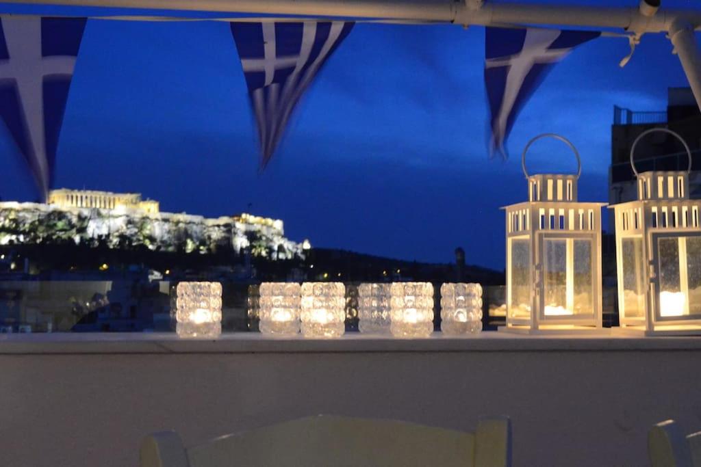 a table with lit up candles in a window at night at Acropolis View Studio in Monastiraki in Athens