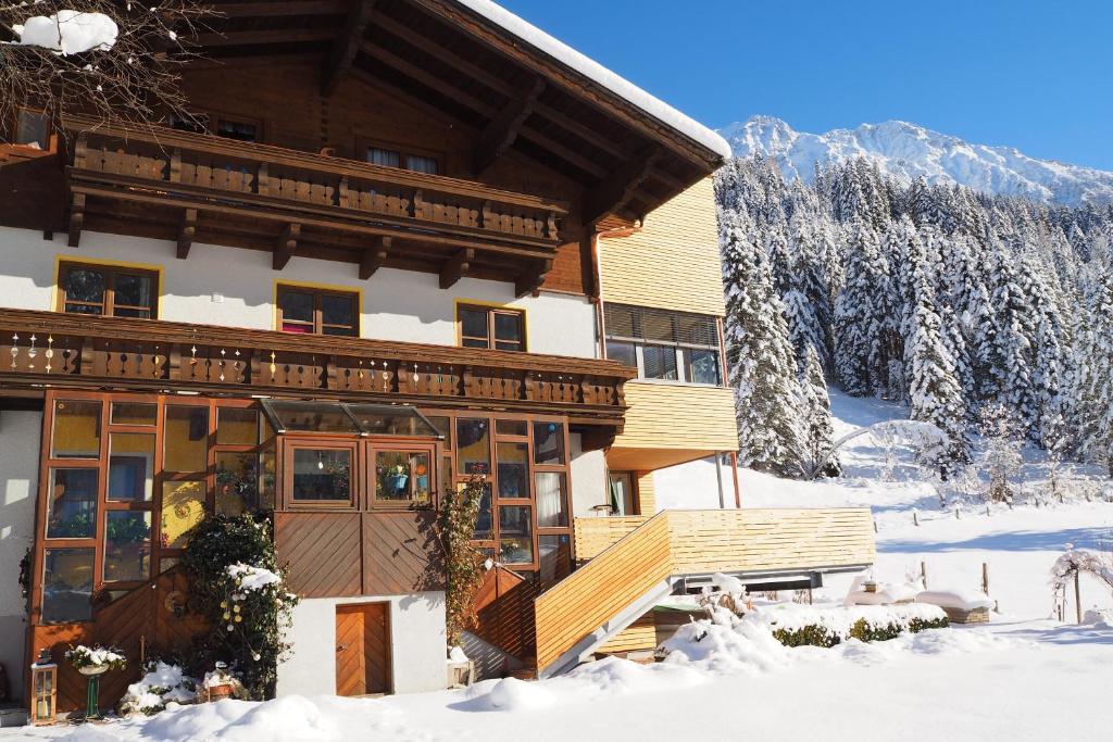 un grand bâtiment dans la neige avec des arbres enneigés dans l'établissement Fridas, à Kleinarl