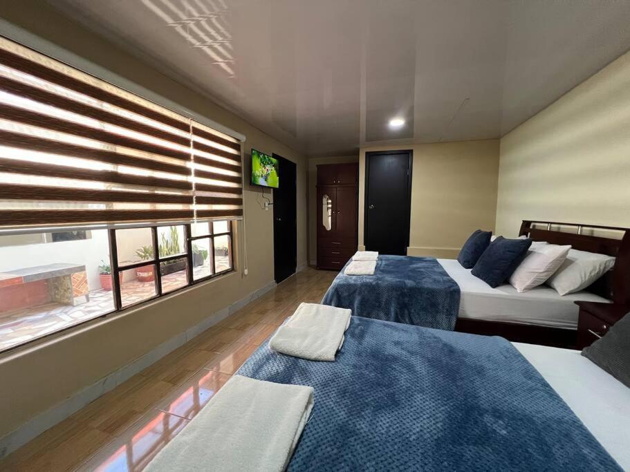 pokój hotelowy z dwoma łóżkami i oknem w obiekcie Sanctuary Apartment 5 bedroom 4 bathroom w Baños