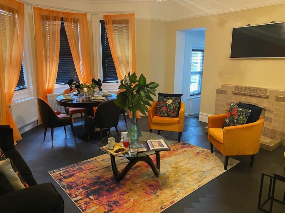 a living room with a table and chairs at The Bell's Self-Service Holiday Flat Bournemouth in Bournemouth