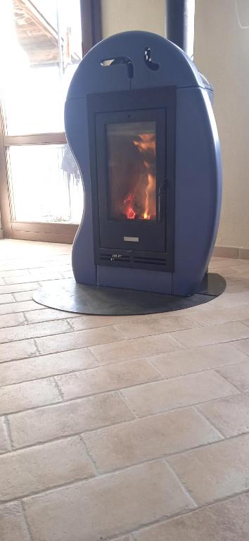 a blue stove sitting on a tile floor with a fireplace at La dimora del castagno in Ormea