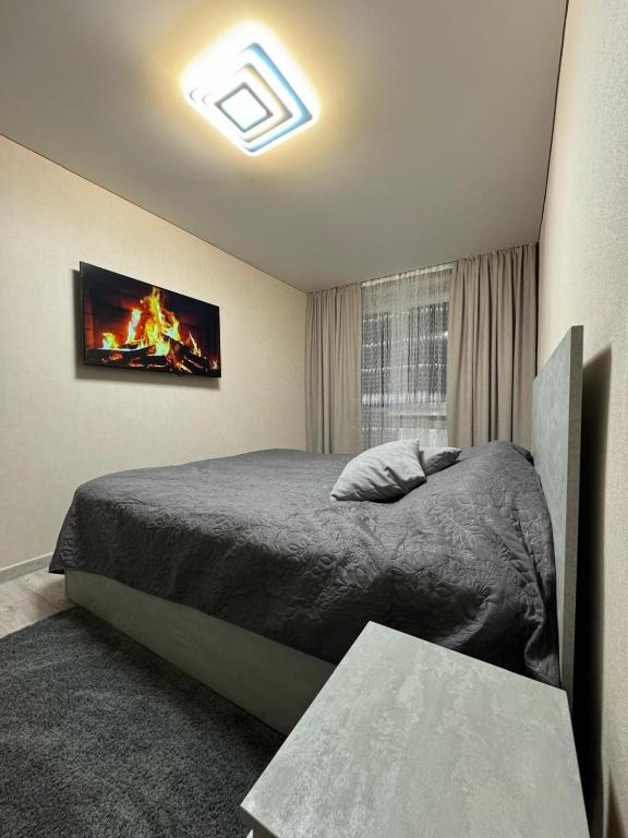 a bedroom with a bed and a tv on the wall at Apartments in Bălţi