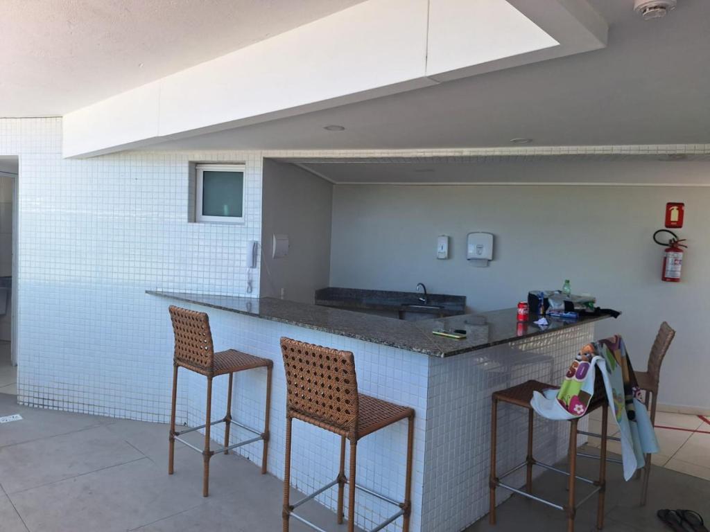eine Küche mit zwei Barhockern und einem Waschbecken in der Unterkunft Apartamento BLUE in João Pessoa