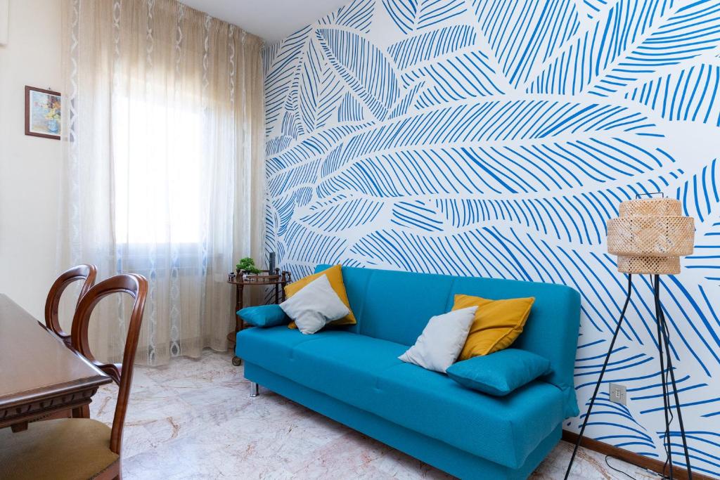 a blue couch in a living room with a blue and white wall at Esclusiva Residenza con 2 Suite in Centro Città, Mare a 750m, Parcheggio a 300m in Pescara