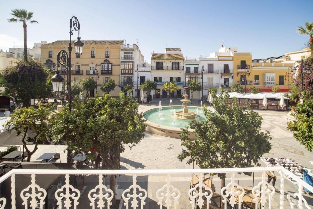 einen Blick vom Balkon einer Stadt mit einem Brunnen in der Unterkunft Apartamento ateneo in Sanlúcar de Barrameda