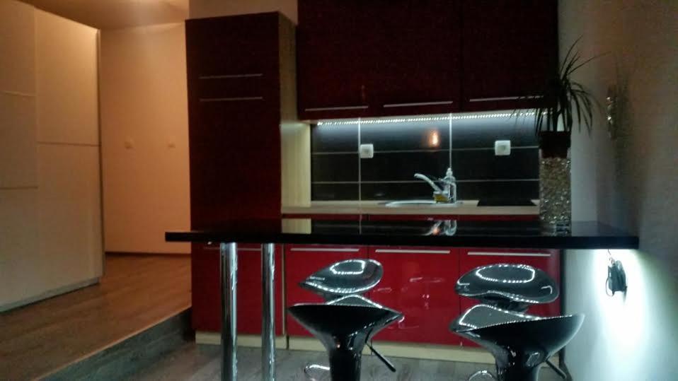 a kitchen with a black counter and some stools at Apartments Jurašić in Ogulin