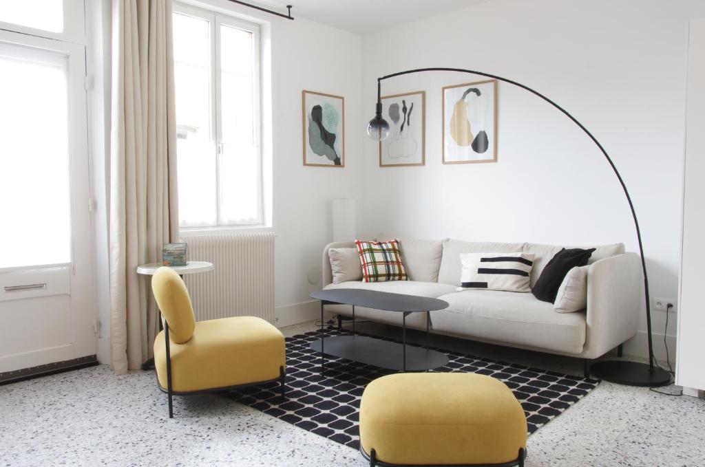 - un salon avec un canapé et deux fauteuils jaunes dans l'établissement Les Sables, au Crotoy