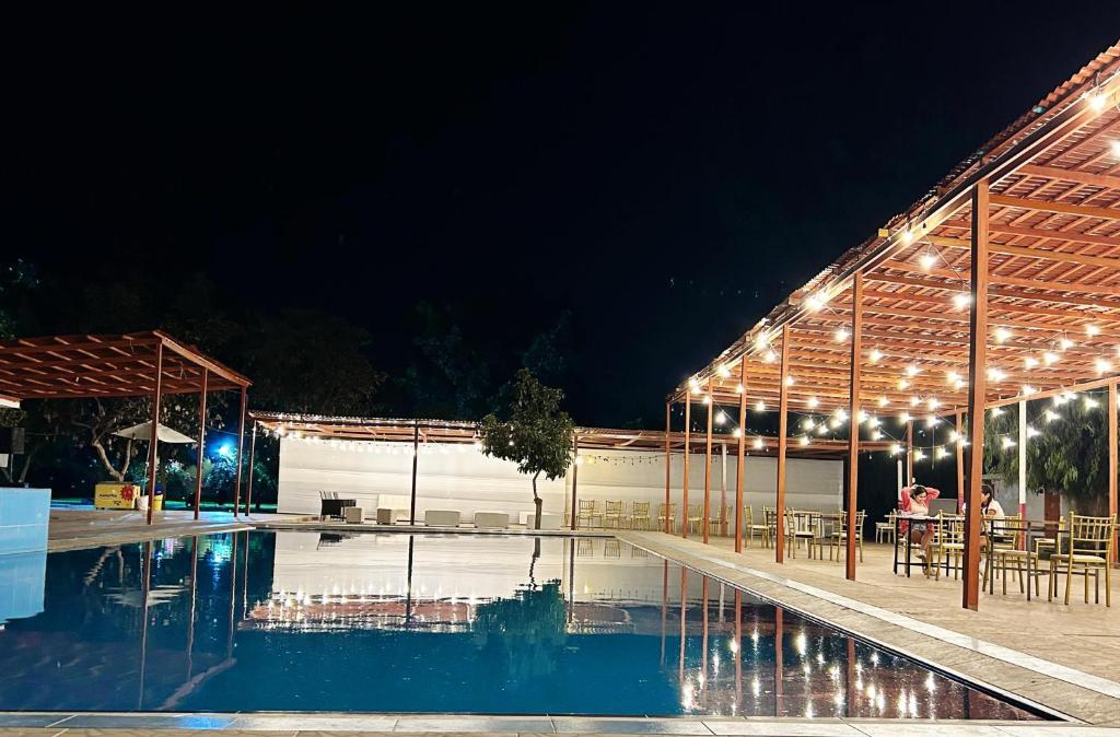 Una piscina de noche con luces encendidas en LOS PECANOS Ica, en Ica