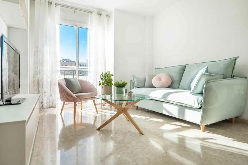 マラガにあるBright Apartment in Central Málaga, 100 m²のソファとガラスのテーブルのあるリビングルーム