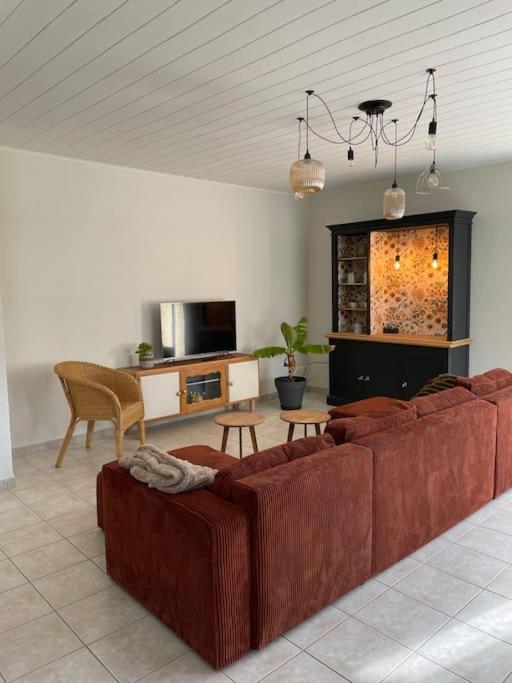 un salon avec un canapé et une télévision dans l'établissement Maison familiale, à Saint-Cyr