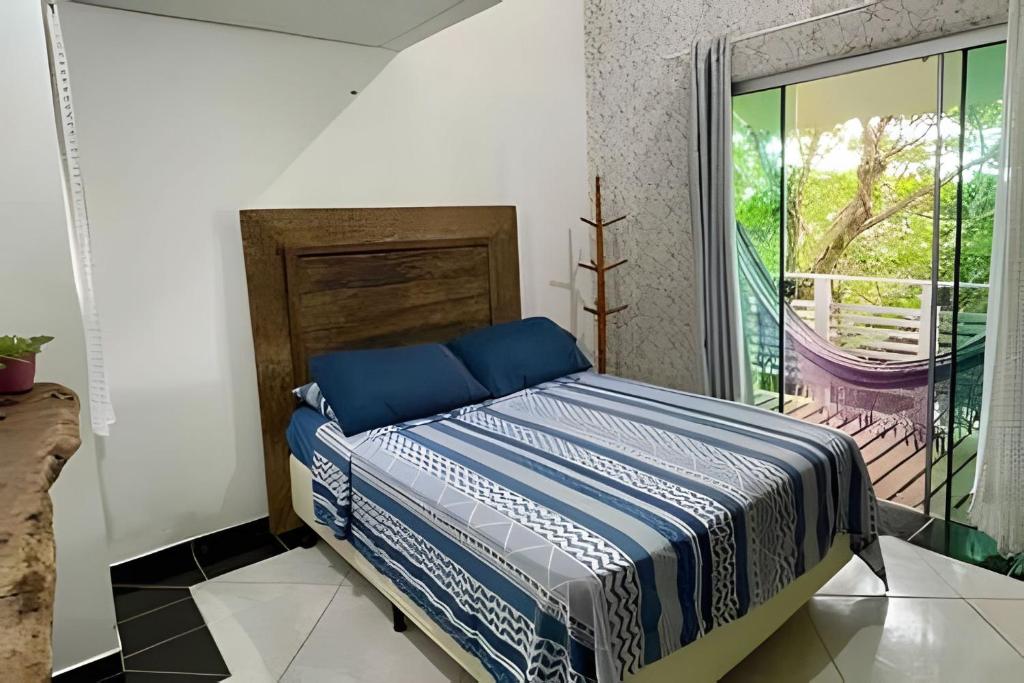 um quarto com uma cama em um quarto com janela em Samauma Floripa Aluguel de Quartos em Florianópolis