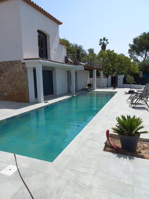 une piscine devant une maison dans l'établissement Appartement au calme avec piscine et terrasse, à Carqueiranne
