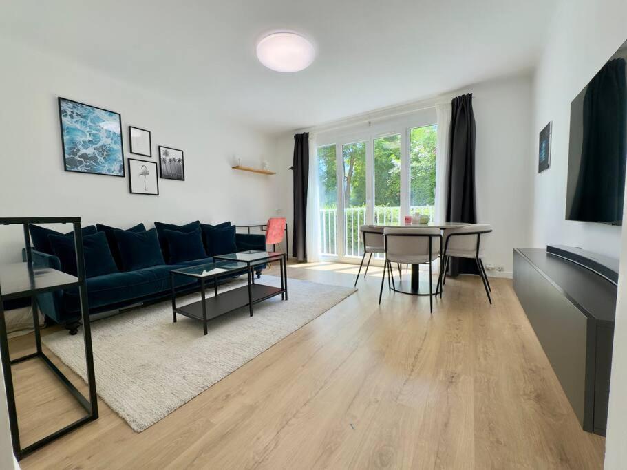 un salon avec un canapé bleu et une table dans l'établissement Le B Plage, Appartement 4 Personnes, Climatisation, Parking, à Antibes