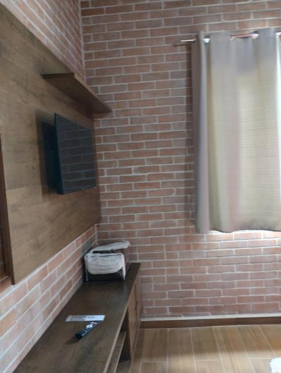 a bathroom with a brick wall and a shower at Recanto das palmeiras in Espera Feliz