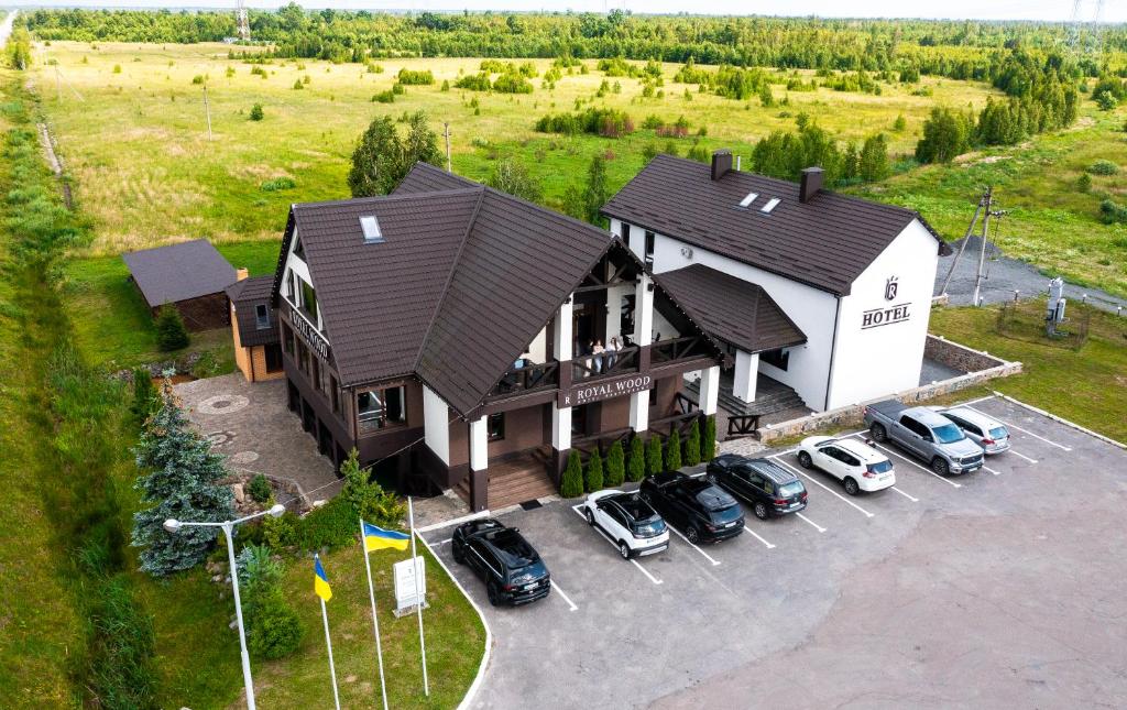 an aerial view of a house with cars parked in a parking lot at Royal Wood Hotel in Rokytne