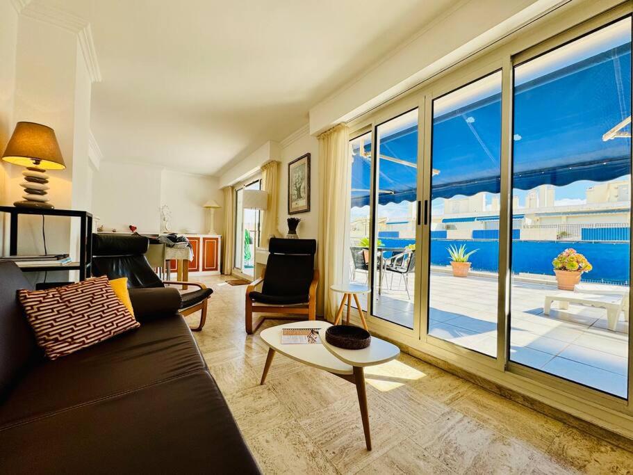 un salon avec un canapé et une grande fenêtre dans l'établissement Le Pam'S, Apt de Standing pour 4 prs, Terrasse et Parking, à Antibes