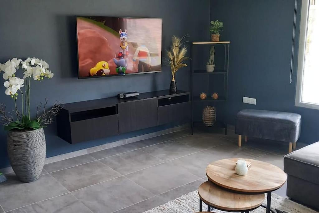 a living room with a tv on a blue wall at Modern Appartement Noord Jan Thiel #2 in Willemstad