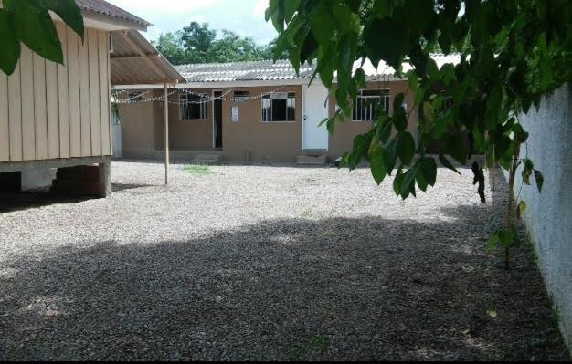 a house with a gravel yard in front of a building at Cantinho da Nonna in Morretes