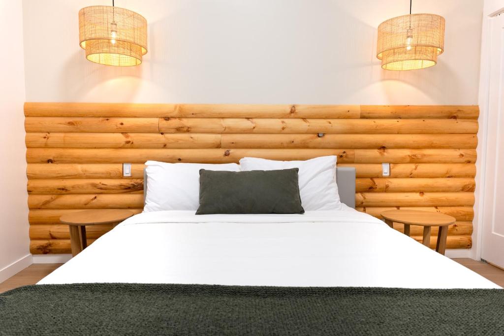 une chambre avec un grand lit blanc avec deux tables dans l'établissement #1 - Luxurious 2Bds - Self Check in - Plateau - St-Denis - AC - TV, à Montréal