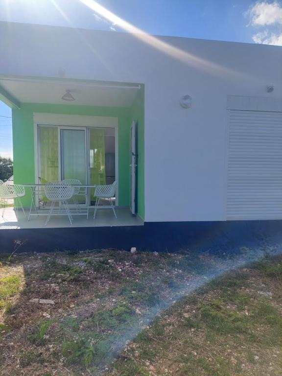 a porch of a house with two chairs and a refrigerator at Gaby villa in Capesterre