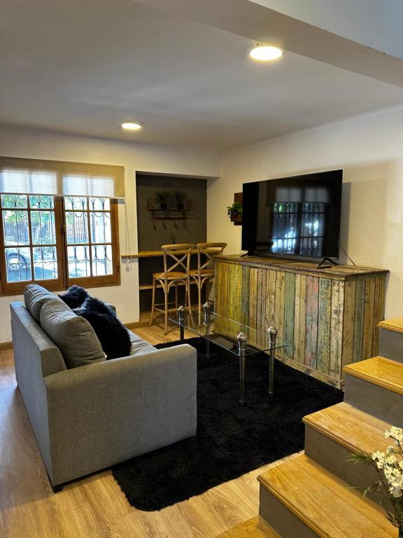 a living room with a couch and a flat screen tv at Rincón de Arístides in Mendoza