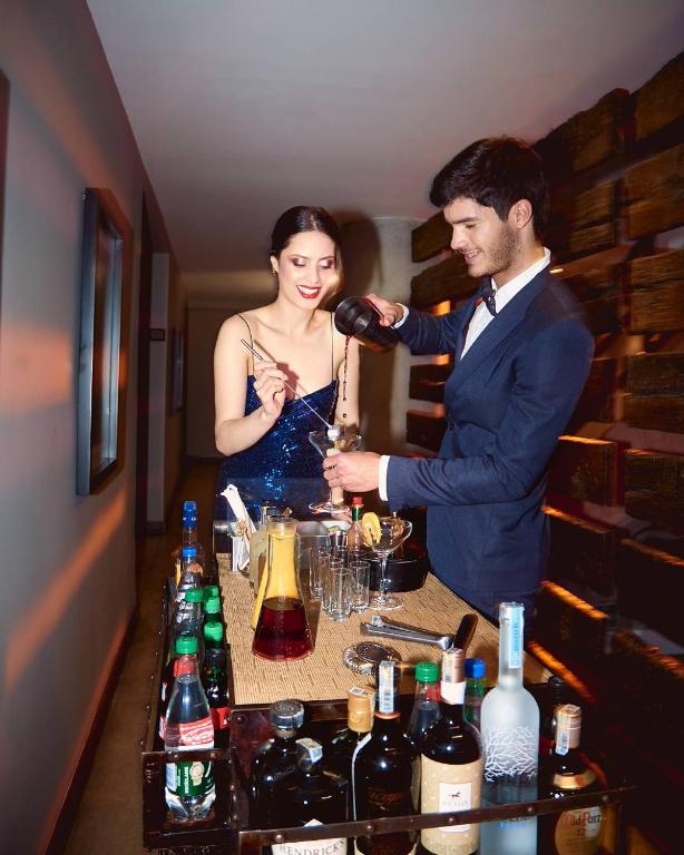a man and a woman standing at a bar mixing drinks at The Charlee Hotel in Medellín