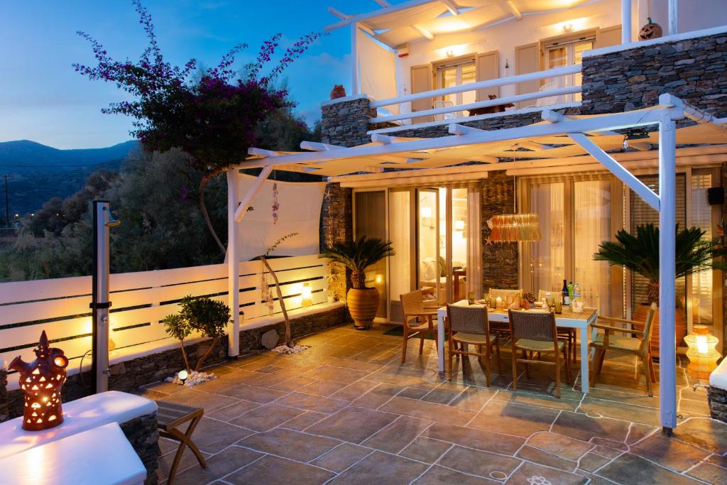 a patio of a house with a table and chairs at Miles Away Sifnos - Beachfront House in Platis Yialos Sifnos