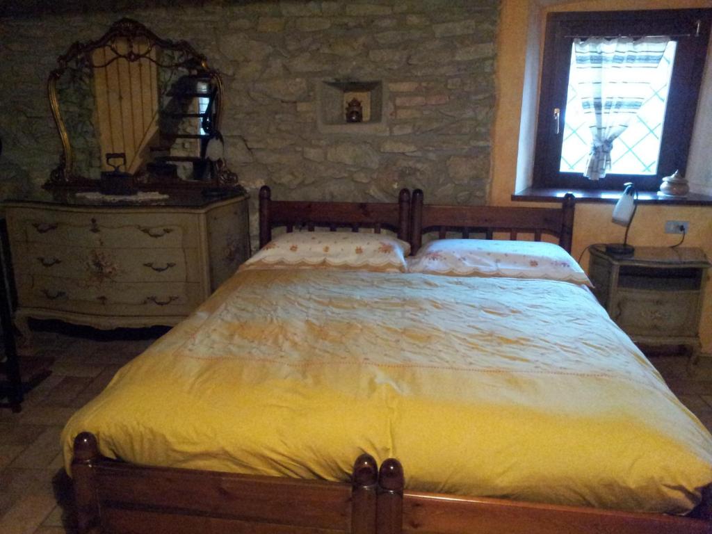 una camera con un grande letto e un muro di pietra di Agriturismo Cascina Ronchi a Palazzago